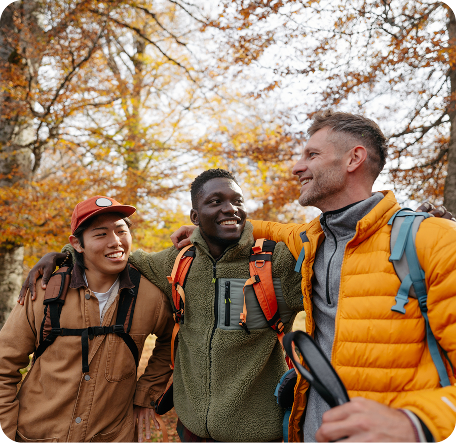 Three friends hiking in autumn forest.