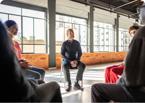 Group meeting in a sunlit room.